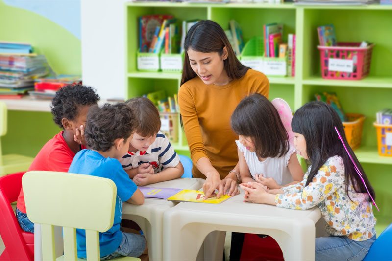 daycare-teacher-reading-to-children